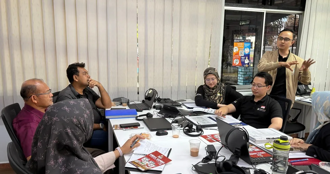 The NakHalal team working through documents with business owners around a table